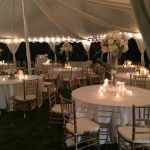 Catered Wedding tent setup with chavari chairs, lighting, center pieces